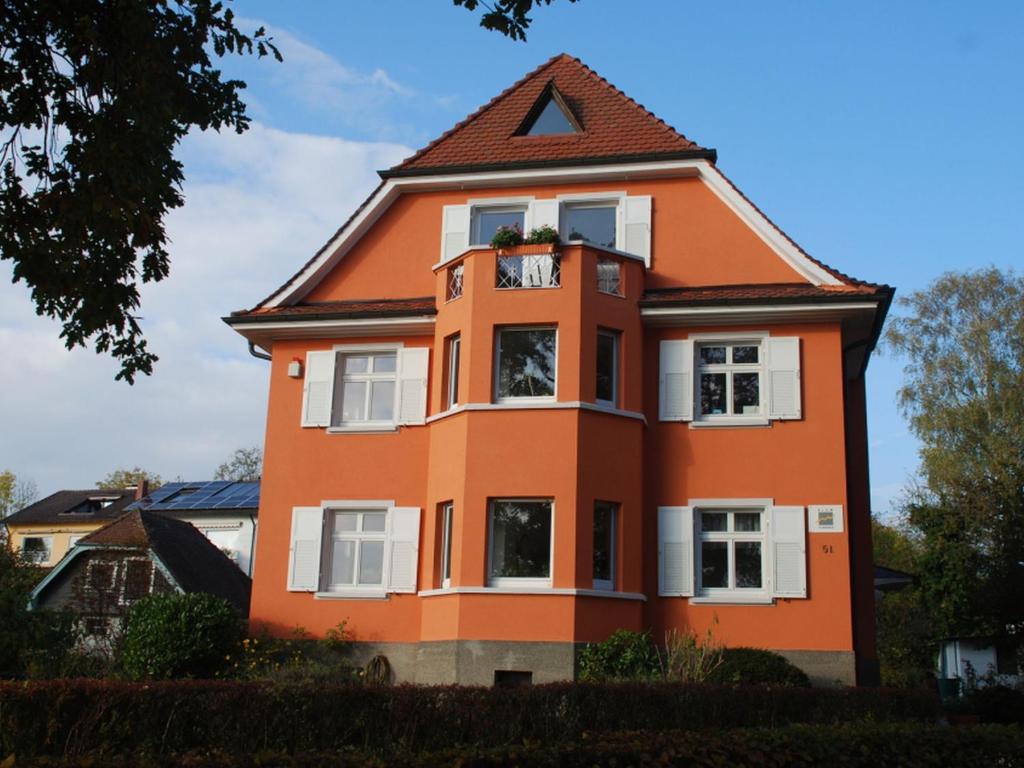 康斯坦茨Blum Ferienwohnung的橙色房子,有 ⁇ 帽屋顶