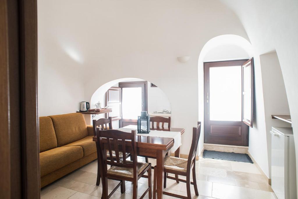阿尔贝罗贝洛图利德亚酒店的客厅配有桌子和沙发