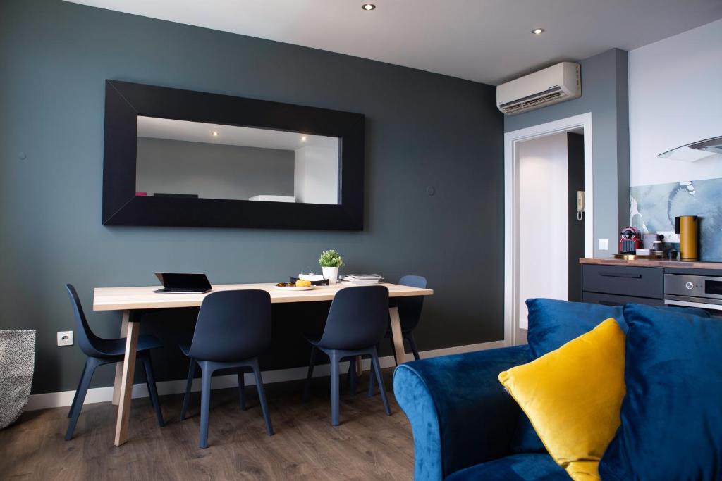 圣克鲁斯-德特内里费Home2Book Stunning&Design Apartment Santa Cruz的客厅配有桌子和蓝色沙发