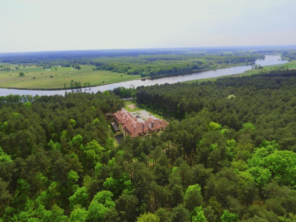 德罗希琴Hotel Drohicki的河流旁树林中房屋的空中景观