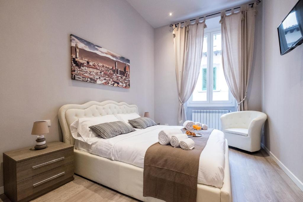 佛罗伦萨Silver Novella Luxury Apartment - Centro Storico的卧室配有白色的床和椅子