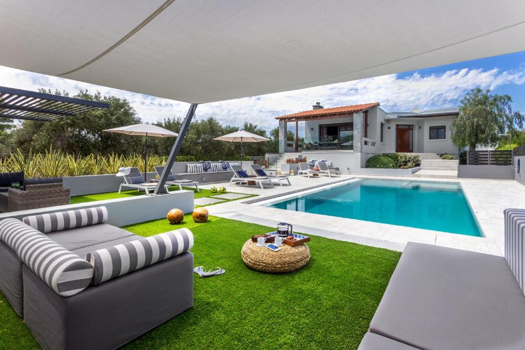 考瑙皮迪亚纳Villa Ampelaki - with heated pool的一个带游泳池和别墅的后院