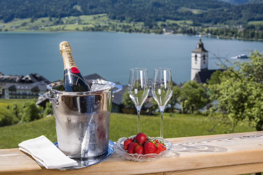 圣沃尔夫冈阿尔特罗伊特霍夫酒店的桌子上放着一桶香槟和两杯酒杯
