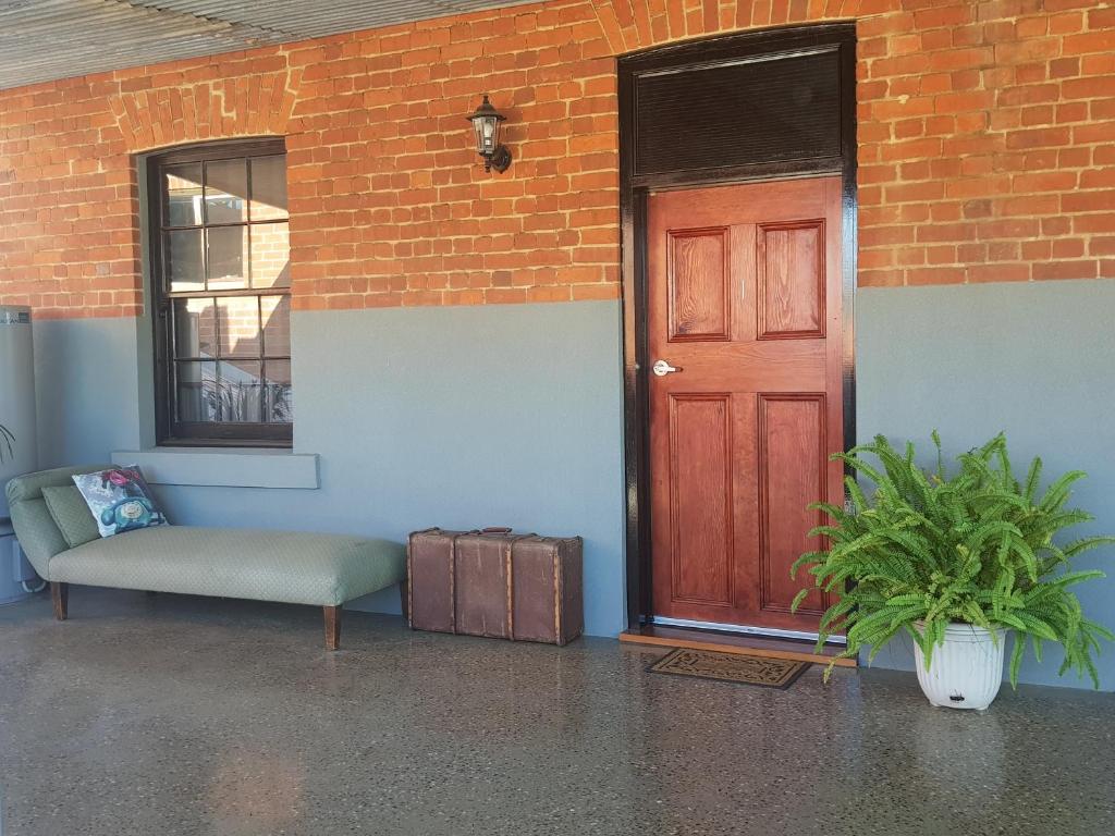 旺加拉塔Sublime Spa Apartments的砖楼旁的红门和长凳