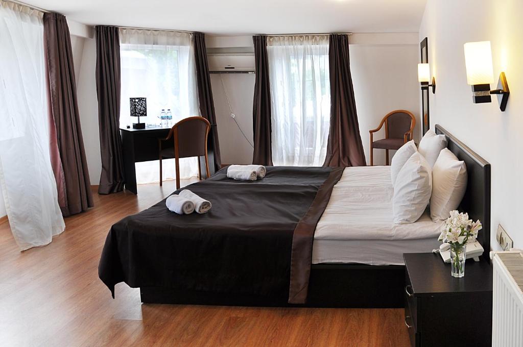 第比利斯科尔诺酒店的一间卧室配有一张大床和一张书桌