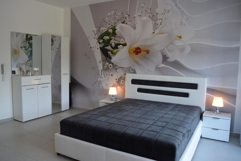 蒂瓦特Kristina Apartments的卧室配有一张墙上鲜花的床