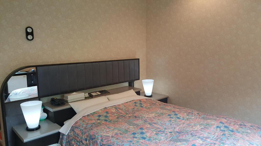 室兰桑戈酒店（仅限成人）的一间卧室配有一张大床,两盏灯