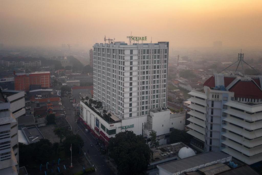 泗水The Square Surabaya Hotel的日落时分在城市里高大的白色建筑