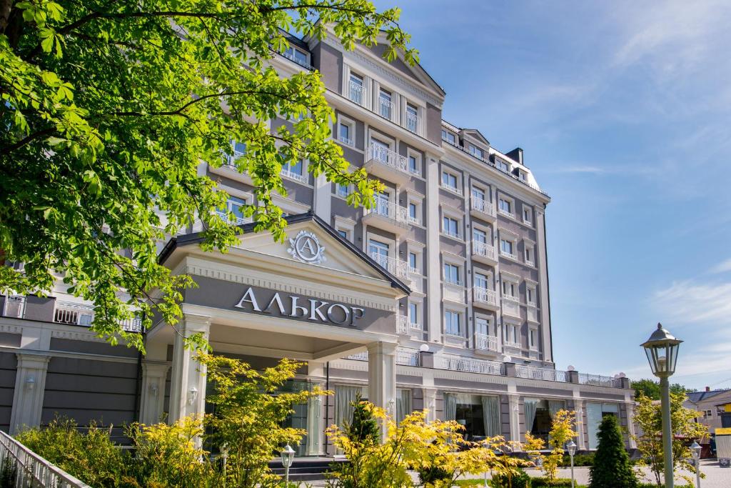 特鲁斯卡韦茨Hotel Alkor的一座白色的大建筑,上面有秋子标志