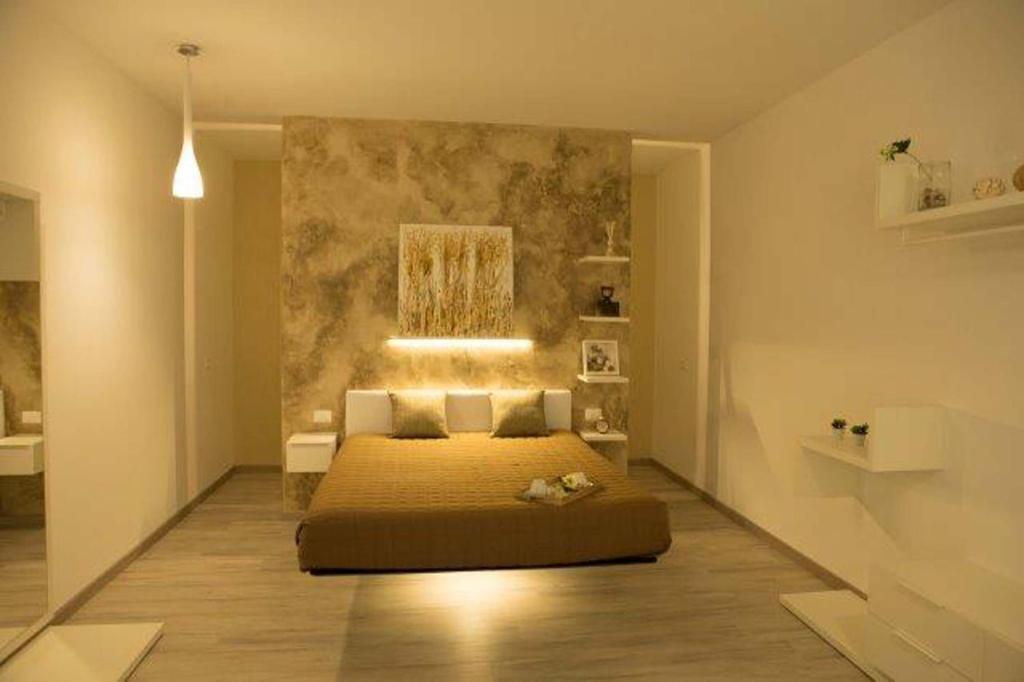 莱切Nidi di Feo的卧室配有一张床,墙上挂有绘画作品