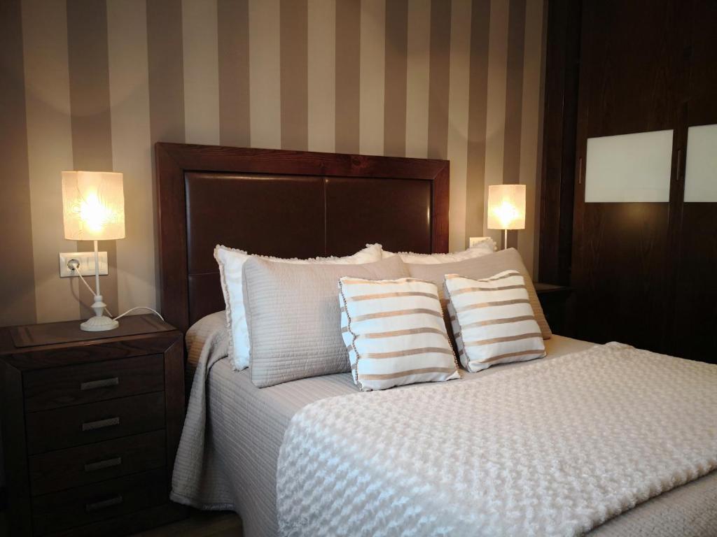 布埃乌Apartamento AGRELO的一间卧室配有一张带枕头的床和两盏灯。