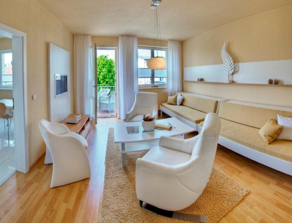 瓦尔内明德Apartments in Warnemuende的客厅配有白色椅子和沙发