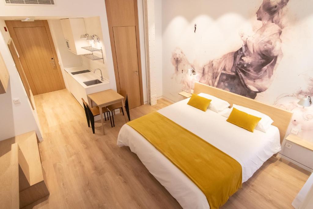 马德里Plaza Mayor Suites & Apartments的一间卧室配有一张大床和一张书桌