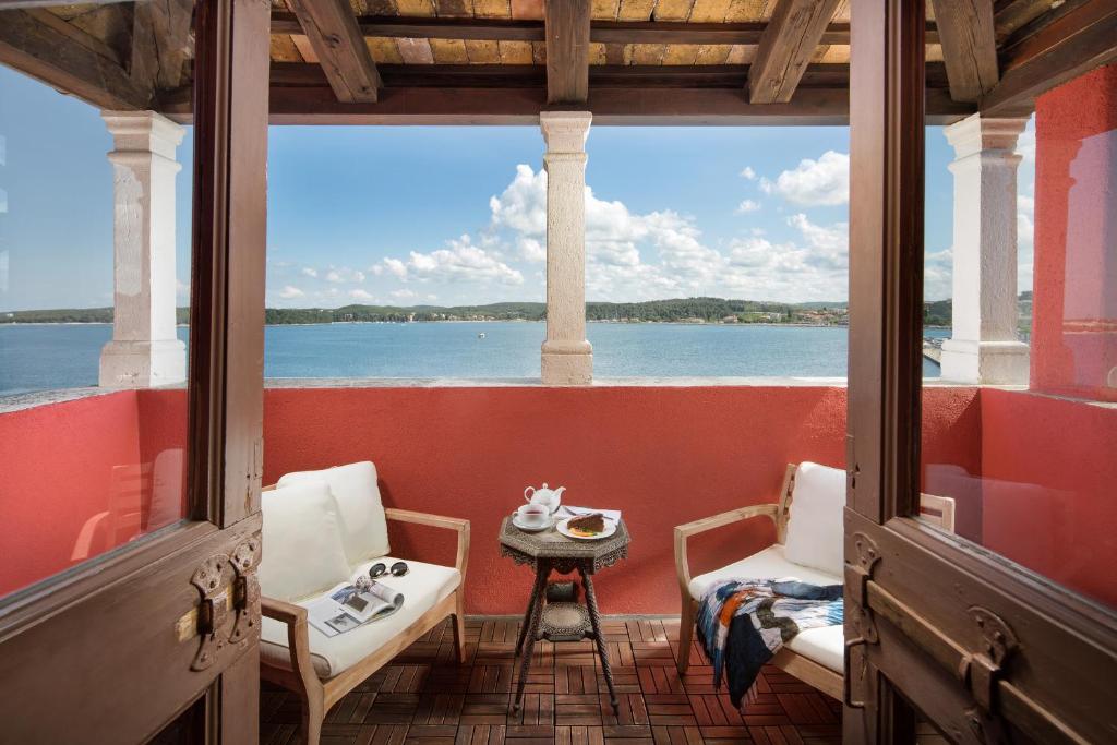 罗维尼海瑞缇吉安吉洛多拉酒店的一个带桌椅的门廊,享有水景