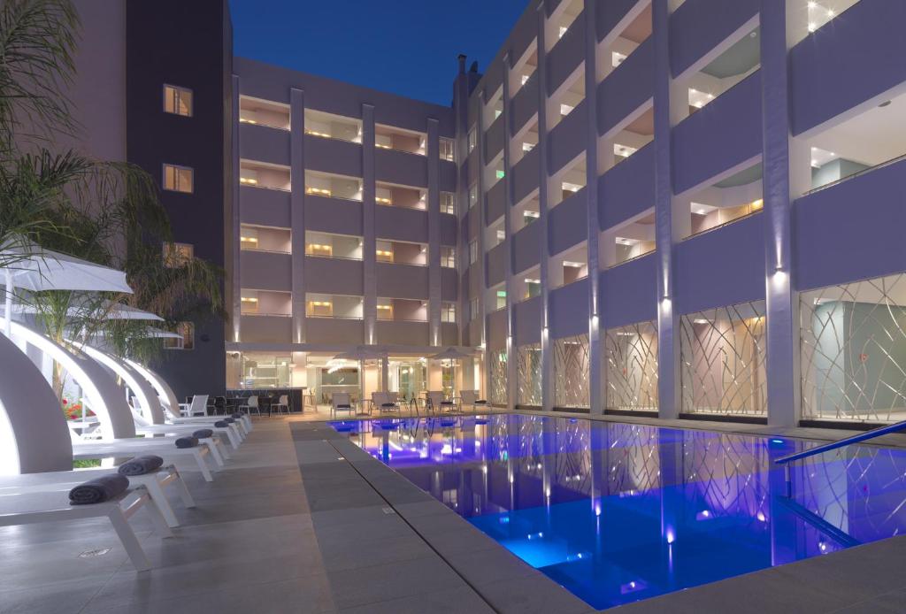罗希姆诺Melrose Rethymno by Mage Hotels的夜间设有游泳池的酒店
