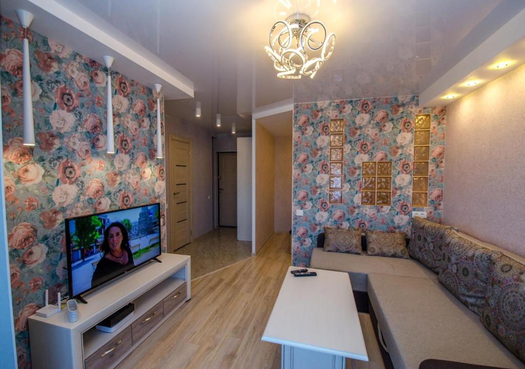 文茨皮尔斯Poruka apartamenti的客厅配有沙发和墙上的电视