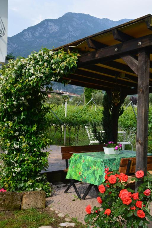 阿科La Casa nel Verde的花园里种满了鲜花,设有桌子和长凳