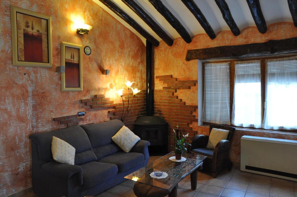莱图尔Casa Rural El Pajar del Portalico的带沙发和燃木炉的客厅