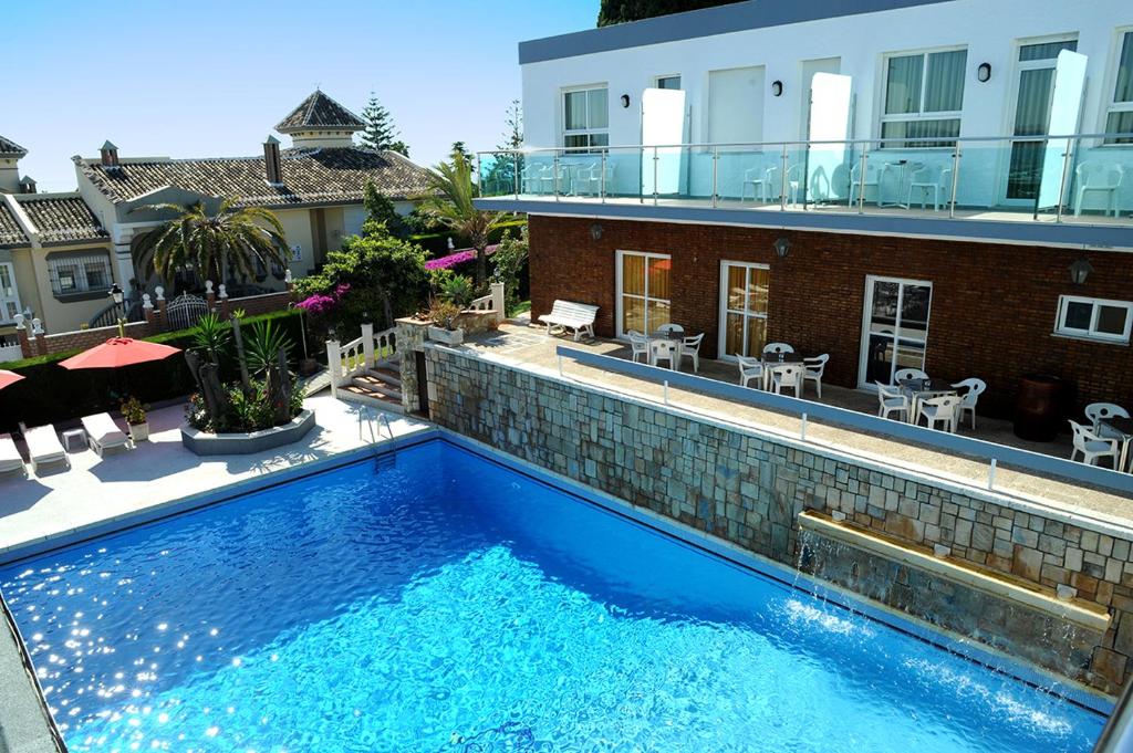 多列毛利诺斯罗萨莱斯度假酒店的一座大型蓝色游泳池,位于大楼旁边