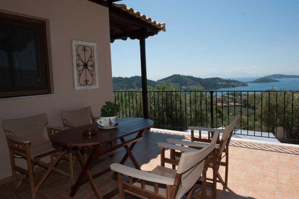 斯基亚索斯镇Apartments Villa L&M Skiathos的带阳台的庭院配有一张木桌和椅子