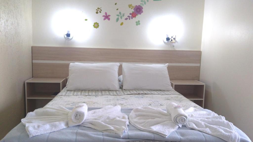 伊瓜佩Hotel Itamiaru的一间卧室配有带毛巾的床