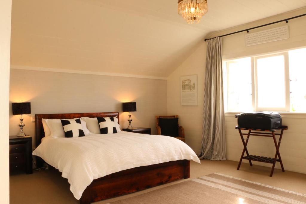 纳皮尔历史科伦索别墅的一间卧室设有一张床、一个窗口和一台电视