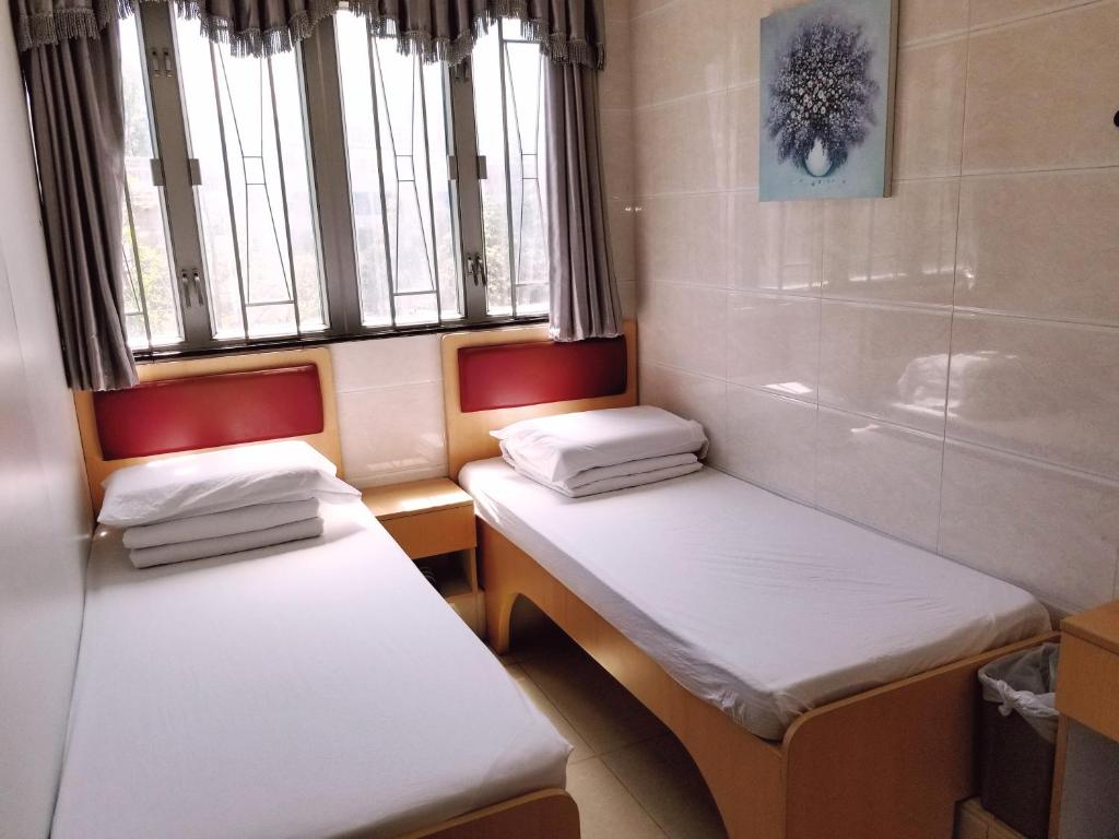 香港亚洲旅游宾馆的带窗户的客房内设有两张单人床。