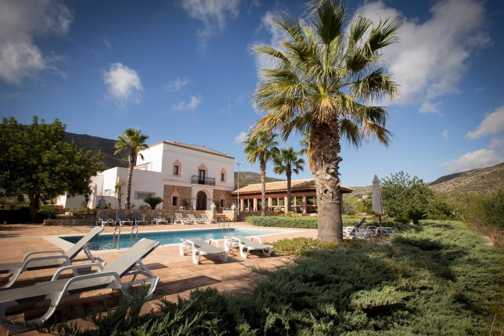 莱斯卡瑟斯-达尔卡纳Hotel Cal Naudi的棕榈树别墅和游泳池