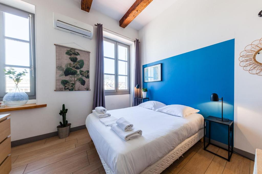 马赛JADE - LES COCONS的一间卧室配有一张大床和蓝色床头板