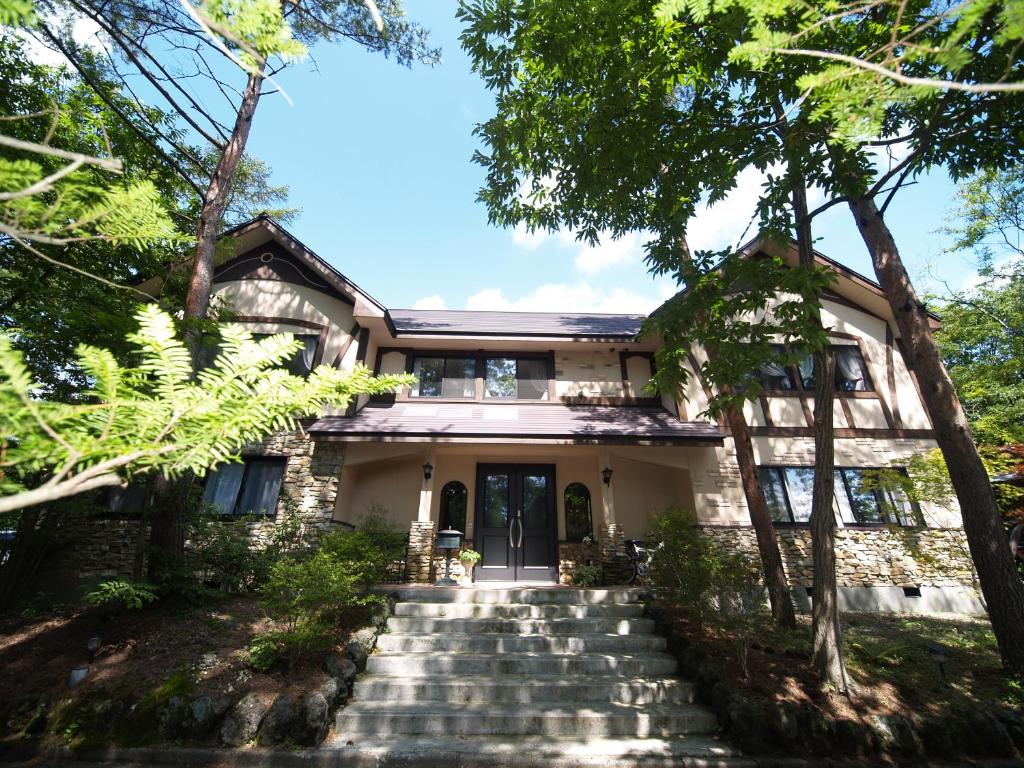 轻井泽ピッコロホテル オペラ軽井沢的房屋设有通往前门的楼梯