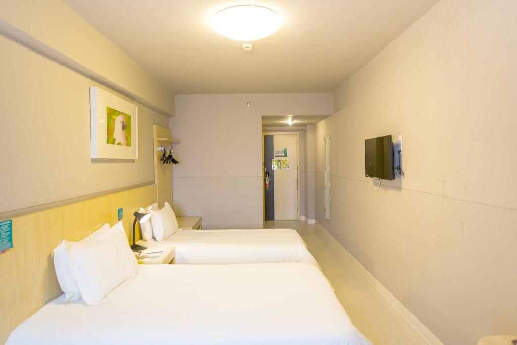合肥锦江之星合肥金寨路中科大酒店的一间酒店客房,设有两张床和电视
