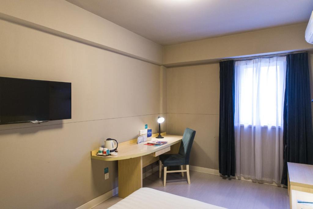 信阳锦江之星风尚信阳东方红大道文化中心酒店的酒店客房配有书桌和电视。