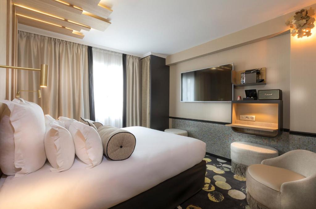 巴黎杜卡德安酒店的酒店客房带一张大床和一把椅子
