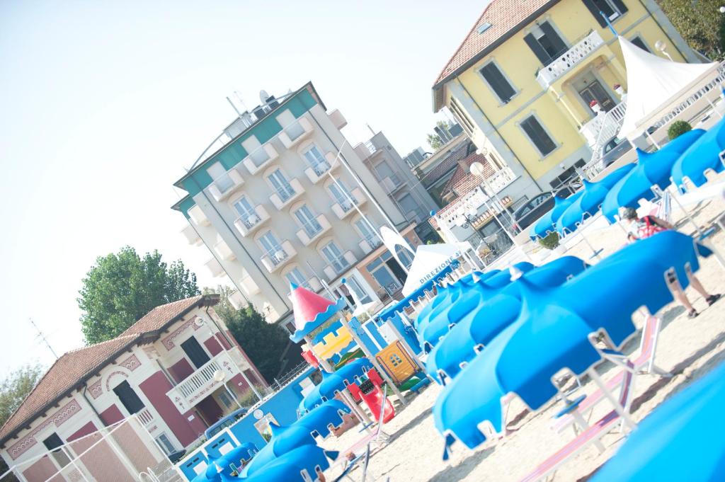 里米尼Hotel Alsen的海滩上的一组蓝色椅子