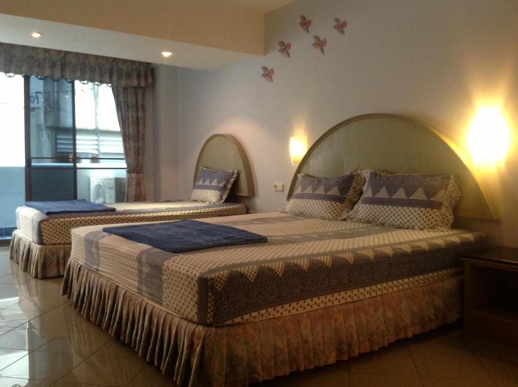 卡伦海滩诸穆霍斯酒店的一间卧室配有两张带蓝色毯子和枕头的床