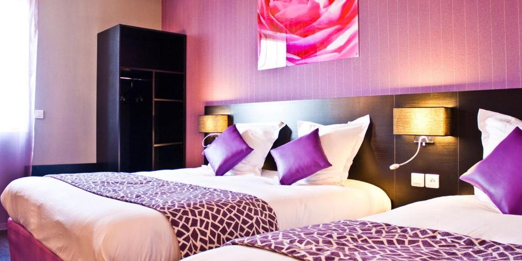 德勒The Originals City, Hôtel des Lys, Dreux (Inter-Hotel)的酒店客房配有两张带紫色枕头的床