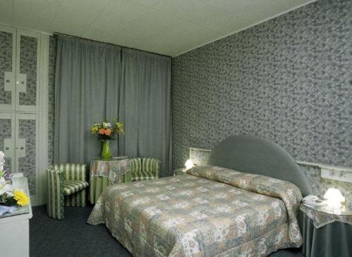 米拉伊尔博其罗酒店的卧室配有一张床和一张桌子及椅子