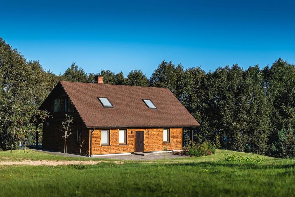 LeitāniLakeside holiday house "Beavers" Bebruciems的砖房,在田野上设有棕色屋顶