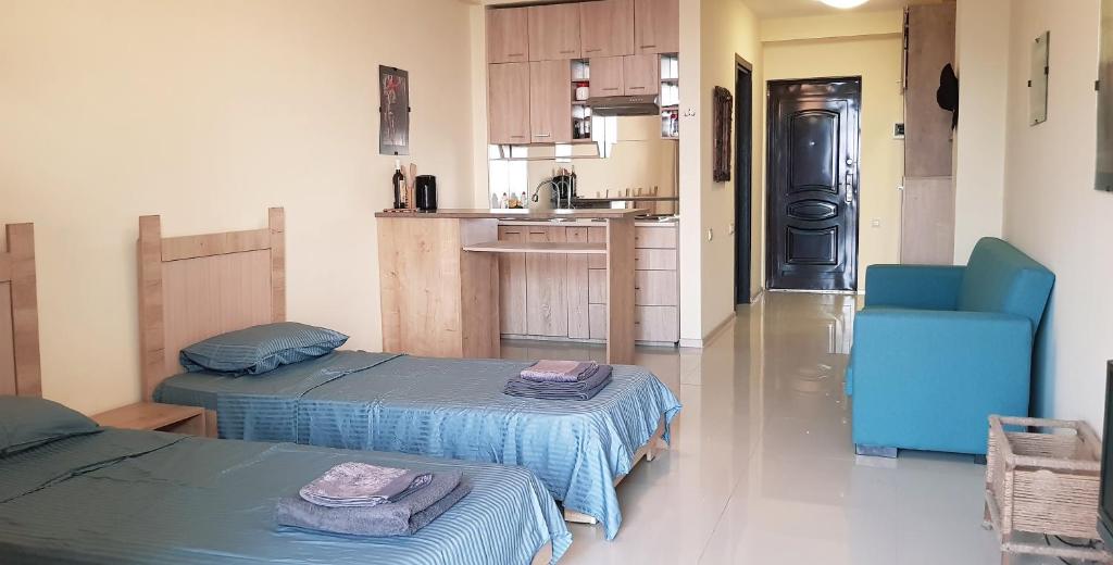 卡瓦拉提Sunset Kvariati Sea Home的一间带两张床的客厅和一间厨房