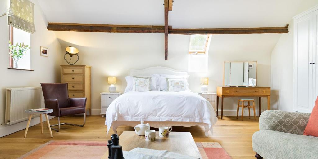 克里克豪厄尔Neuadd B&B Suites的卧室配有白色的床和沙发