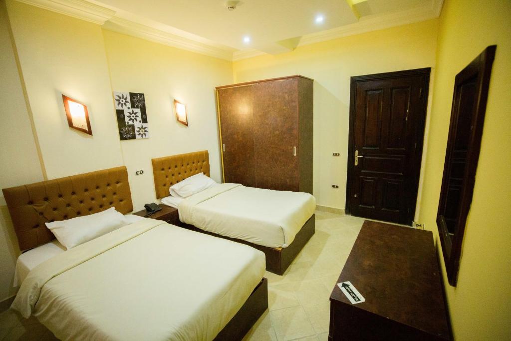 阿莱曼Majorica Marina Hotel的一间酒店客房,设有两张床和一扇门