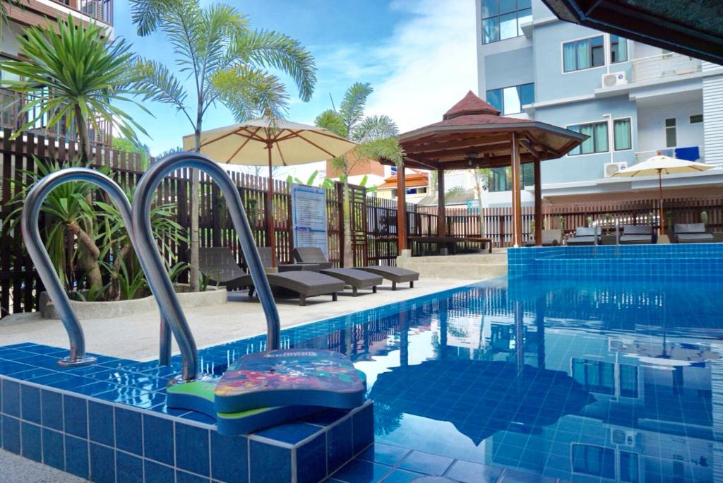 涛岛普拉尼阿马塔酒店的一座带椅子和遮阳伞的游泳池位于一座建筑旁边