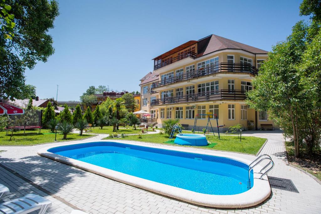 霍斯塔Hotel Staraya Khosta的大楼前带游泳池的房子