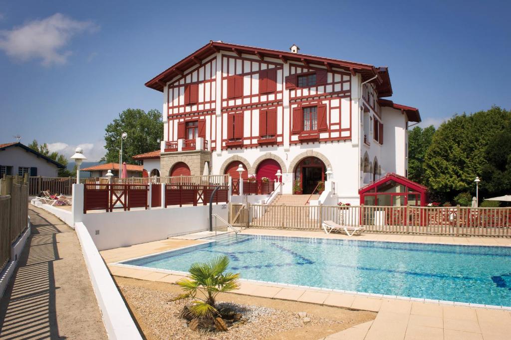 昂代Hôtel & Résidence Vacances Bleues Orhoïtza的房屋前有游泳池的房子