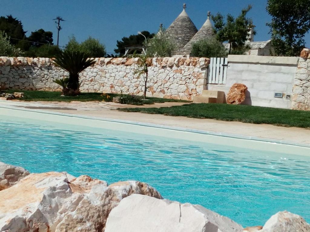 马丁纳弗兰卡Trulli La collinetta的蓝色海水和石墙的游泳池