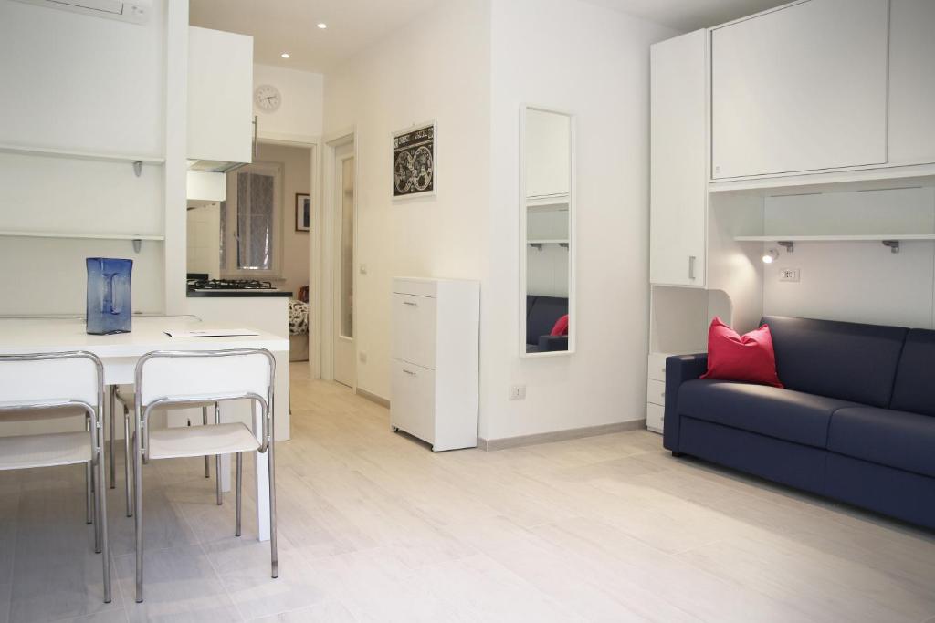 费扎诺Appartamento L'ONDA - 1 via Provinciale的厨房以及带沙发和桌子的客厅。