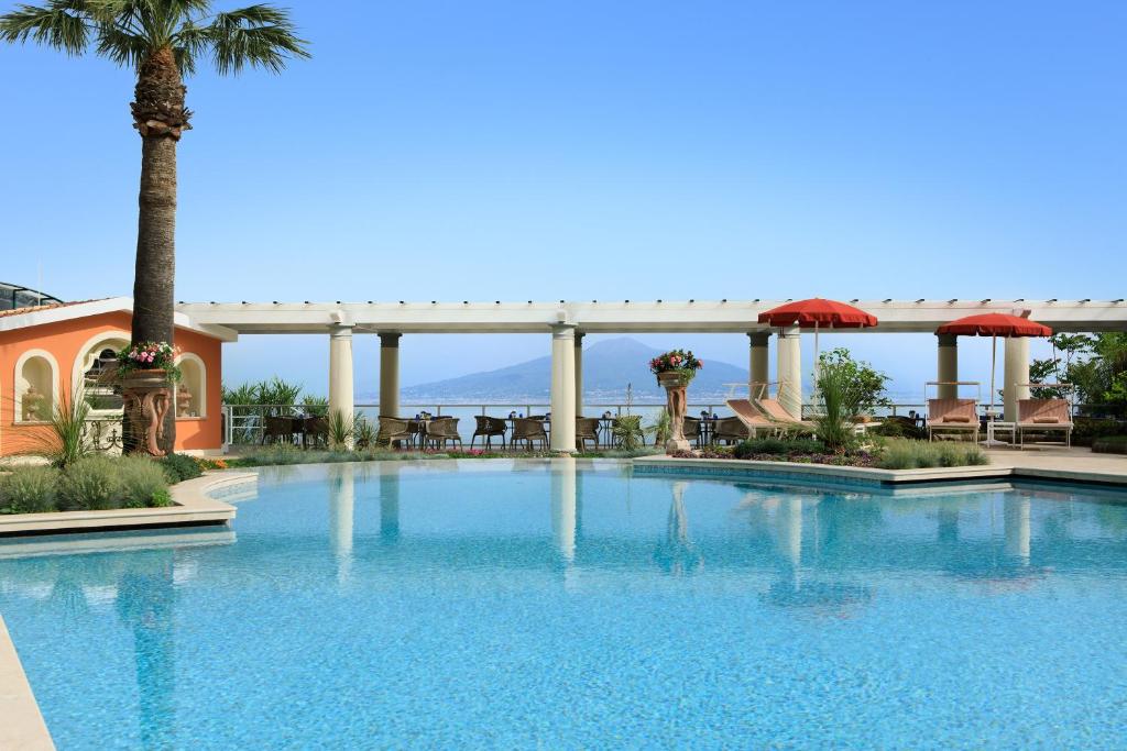 索伦托皇家大酒店的一座棕榈树和桥梁的大型游泳池