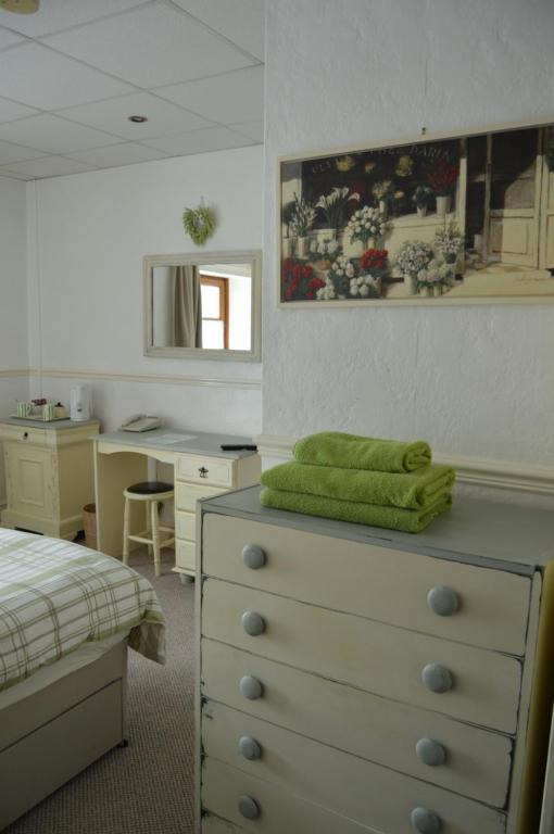 巴里港Caulfields Hotel的一间卧室配有带绿毛巾的梳妆台
