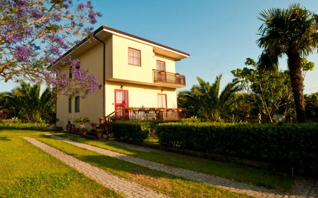 圣欧费米亚拉默齐亚B&B Villa dei Fiori的白色的房子,有红色的门和一条小路