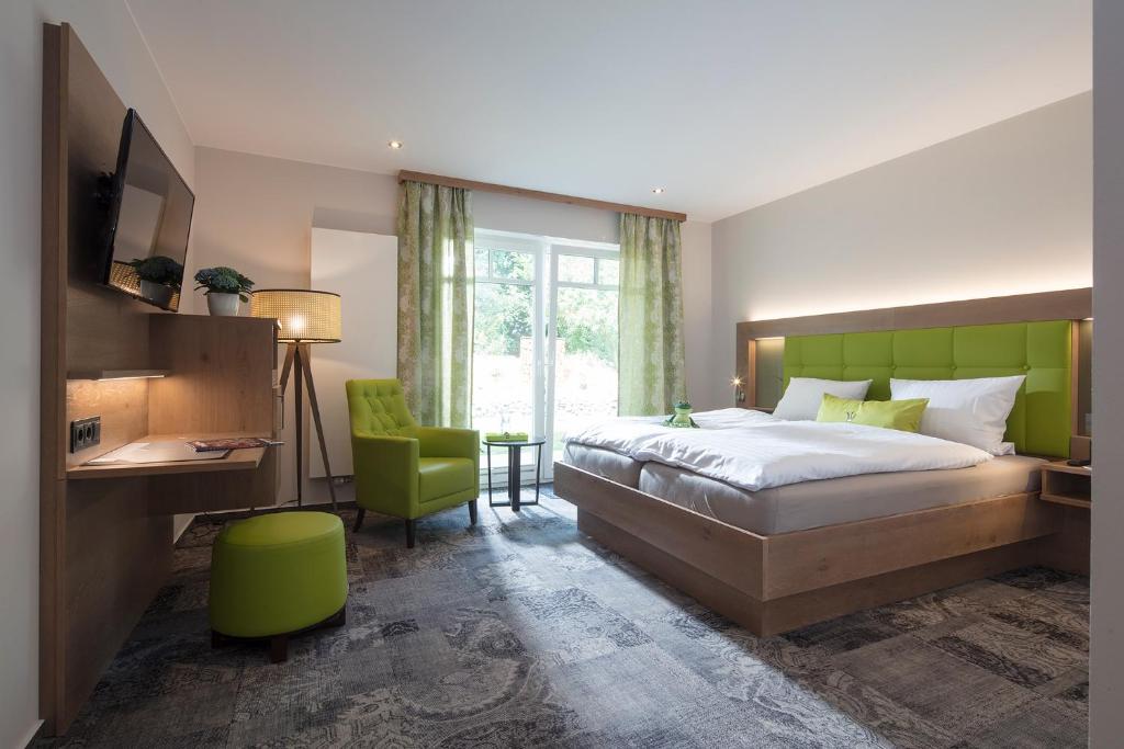 加瑞尔Landhotel Witte-König的一间卧室配有一张床、一张桌子和一把椅子